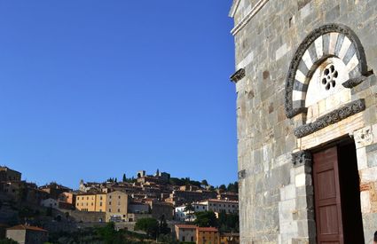 La Pieve romanica di San Giovanni e il borgo medievale di Campiglia Marittima sullo sfondo.